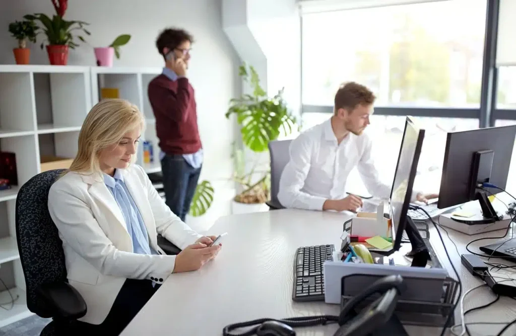 Professionals working at desks in a bright, modern office