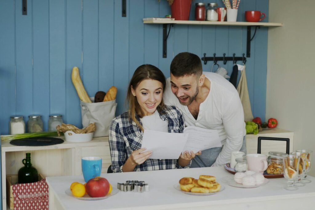 Couple reviewing papers together at a bright kitchen table